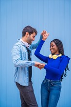 Multiethnic dancer couple of Caucasian man and woman of black ethnicity on a blue background
