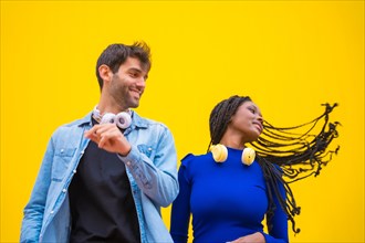 Multiethnic wedding couple of Caucasian man and woman of black ethnicity on a yellow background