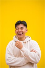 Portrait of a handsome South Korean Asian man in basic clothes smiling isolated over yellow background