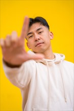 Portrait of a south korean man in basic clothes over yellow background