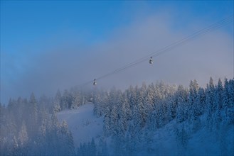 Gondola lift in Lenggries to the Brauneck ski area under a bright blue sky in the morning