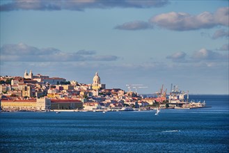 View of Lisbon over Tagus river from Almada with yachts tourist boats at sunset