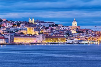 View of Lisbon over Tagus river with ferry boats in evening twilight