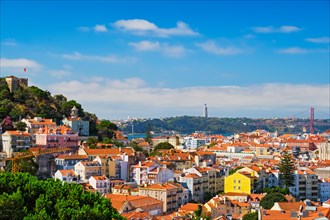 Lisbon famous view from Miradouro dos Barros tourist viewpoint over Alfama old city district with St George's Castle and Portugal flag