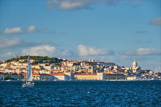 View of Lisbon over Tagus river from Almada with yachts tourist boats on sunset