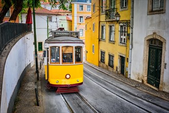 Famous vintage yellow tram 28 in the narrow streets of Alfama district in Lisbon