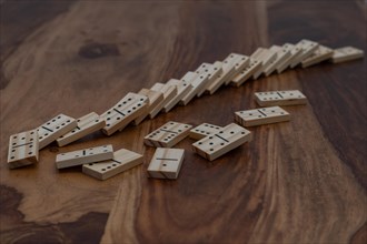 Wooden dominoes in a row on a wooden table
