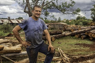 Mature male professional forester standing in sawmill looking at camera