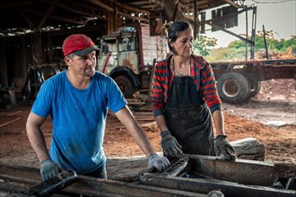 Husband and wife work together in a sawmill
