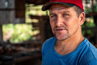 Close up portrait of a handsome male worker wearing a red hat looking at the camera