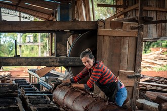 Female worker in work uniform in a sawmill