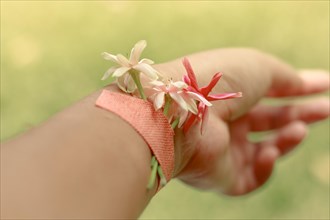 Conceptual photo of flowers plastered on a wrist showing suicide awareness andmental health