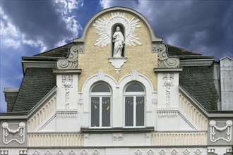 Art Nouveau facade of a residential and commercial building with sculpture of the Virgin Mary