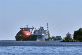LNG or liquified natural gas tanker and LNG carrier used as floating LNG storage and regasification unit and import terminal in port on sunny day in Klaipeda