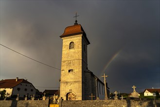 Thunderstorm with rainbow over the Church of the Nativity Église de l'Assomption in Les Plains-et-Grands-Essarts