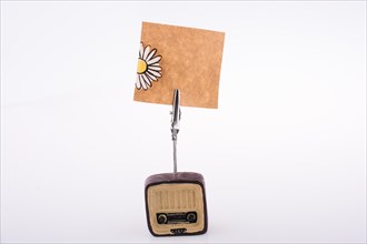 Note paper attached to an retro styled radio on a white background