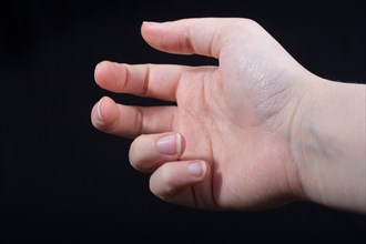 Five fingers of a child hand partly seen in black background