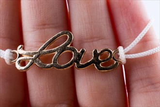 Love written with l letters made of metal in hand