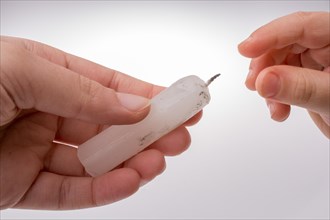 White candle stick in hand on a white background