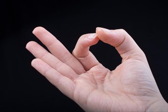 Hand gesturing sign ok okay agree on black background