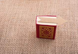 Paper arrow and Islamic Holy Book Quran in mini size