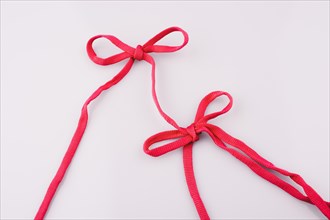 Ribbon of shoe lace of red color on plain background in view
