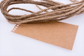 Piece of paper and linen rope on a white background