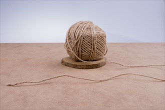 Roll of brown color linen string on brown background