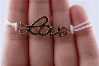 Love written with l letters made of metal in hand