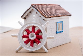 Steering wheel placed beside a little model house