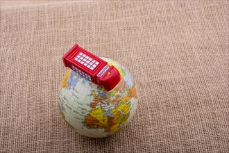 Globe with a telephone booth on canvas background