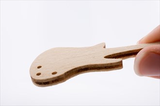 Mini wooden guitar model in hand on a white background
