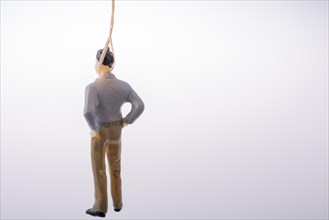 Man figurine tied with aa rope on a brown backgorund
