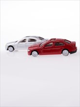 Toy cars and pocket watch on white background