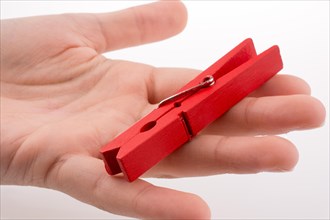 Hand holding a red clothespin on a white background