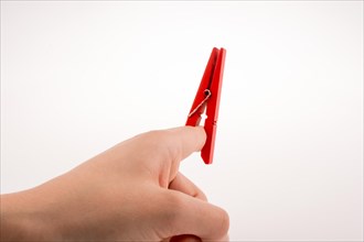Hand holding a red clothespin on a white background