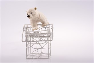 Polar bear cub on the roof of a model house mado of roof