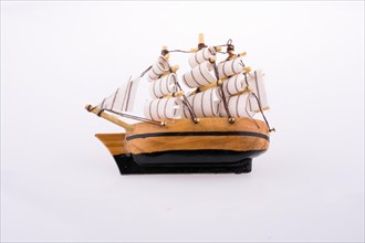 Little wooden model sailboat on white background