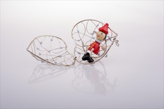 Wooden Pinocchio doll sitting on a heart shaped cage