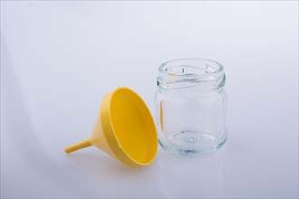 Little glass bottle and a funnel on a white background