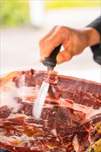 Detail of a man cutting Iberian ham at a wedding or event