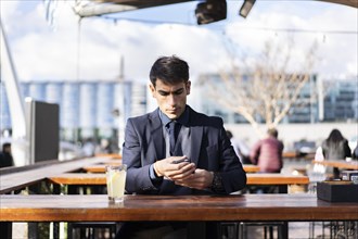 Man checking his smartphone while sitting at a bar