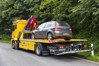 Defective VW Golf on tow truck at roadside