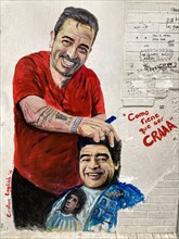 Street art by artist Cristian English shows Diego Maradona getting a haircut