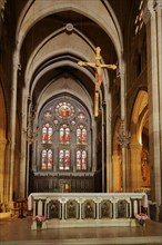 Interior view of the chancel with crucifix of the neo-Gothic St-Baudile church built in 1877