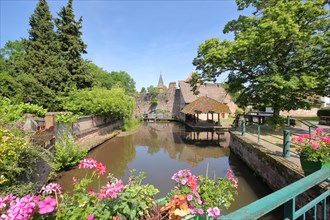 Bridge with floral decoration over the Lauter with view of Lavoir