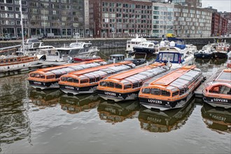 Boats in orange on a canal in Amsterdam
