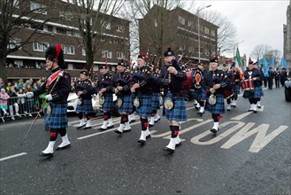 A pipe band with bagpiper in kilts parades through the streets of Dublin at the start of the St Patrick Day's parade