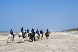 Group of riders riding on the beach of De Panne