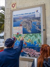 A man points to a map with the town of Porec in Istria on a house wall